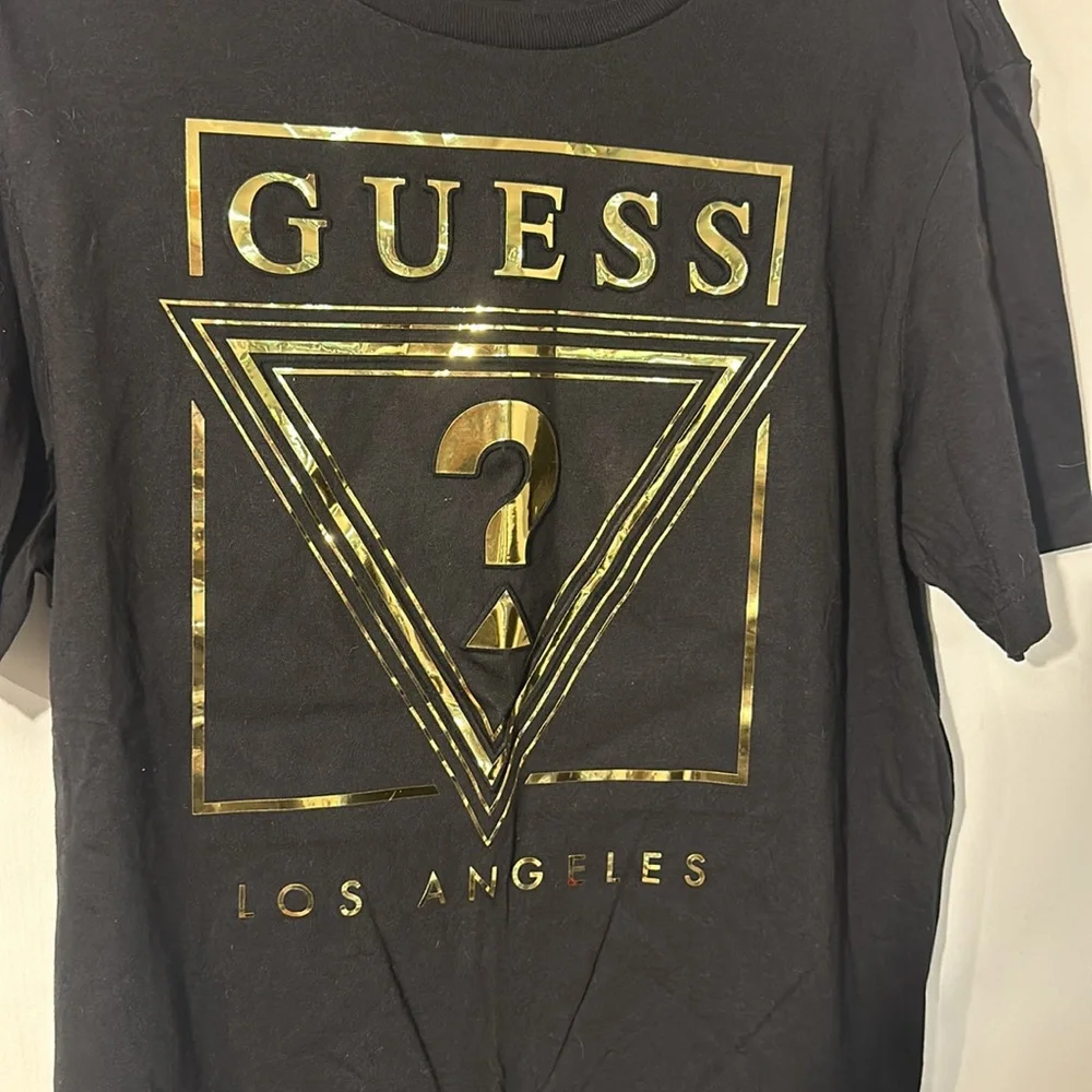 NWOT. Woman’s Guess black and gold T shirt in size L. - Picture 3 of 4